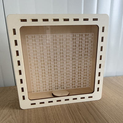 Detail dřevěno-plexisklové kasičky na spoření, zadní pohled na tabulku